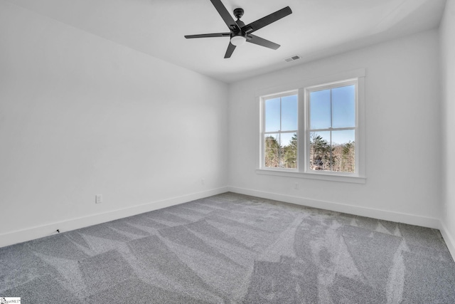 carpeted empty room featuring visible vents, a ceiling fan, and baseboards