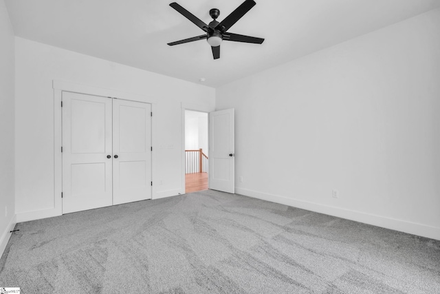 unfurnished bedroom with a closet, baseboards, carpet, and a ceiling fan