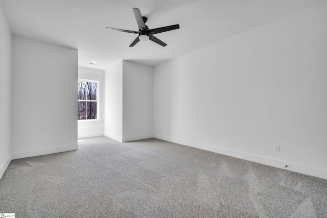 spare room with baseboards, carpet floors, and a ceiling fan