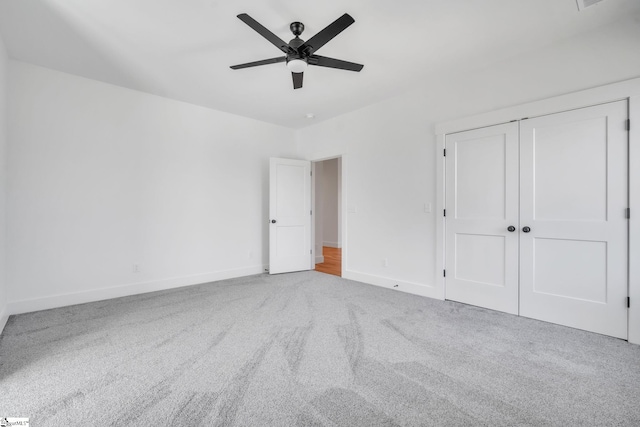 unfurnished bedroom featuring a ceiling fan, carpet, baseboards, and a closet