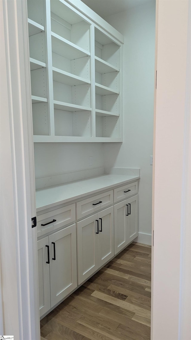 interior space with baseboards and dark wood-style floors