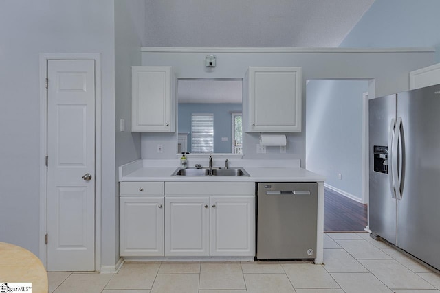 kitchen with a sink, stainless steel appliances, light countertops, and white cabinetry