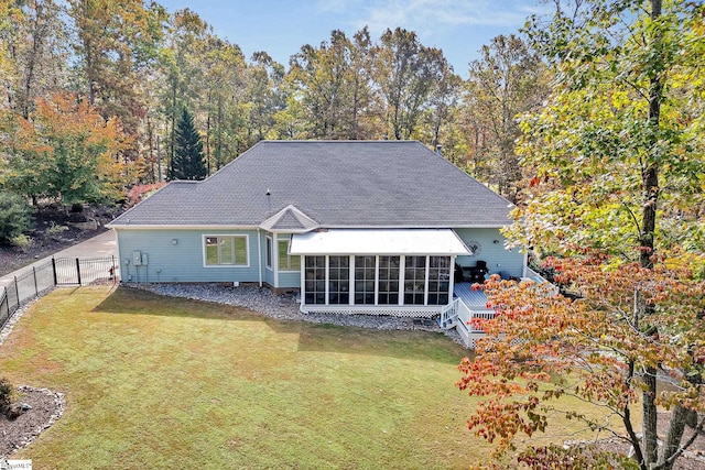 back of house with fence, a yard, and a sunroom