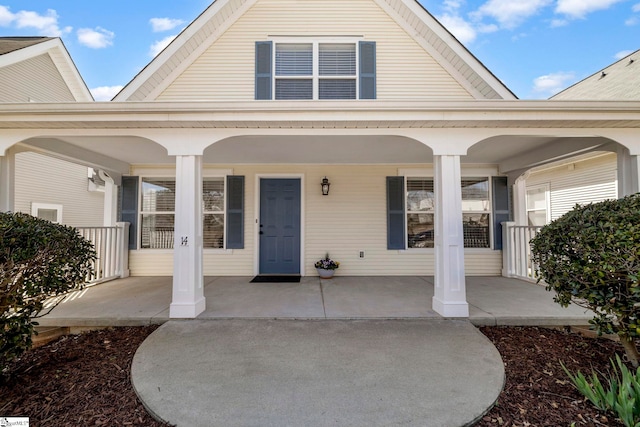 property entrance featuring a porch and a gambrel roof