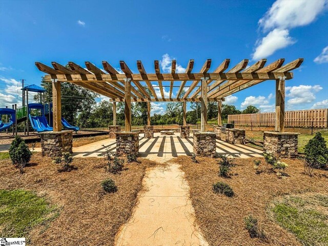 view of yard with a patio area, a pergola, playground community, and fence