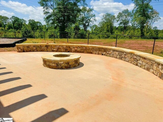 view of patio with a fire pit and fence