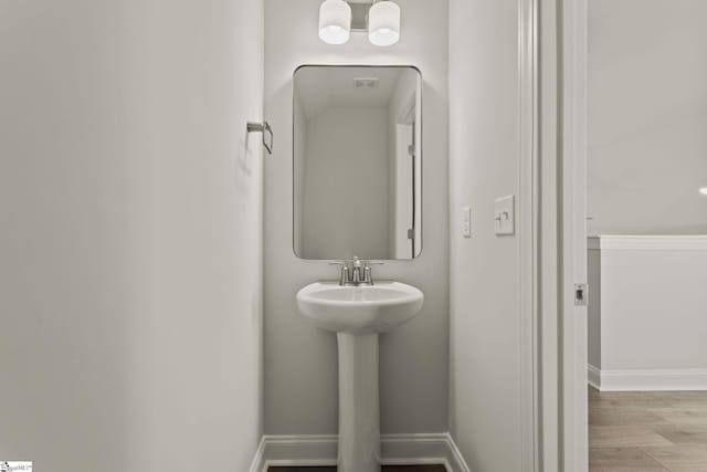 bathroom with baseboards and wood finished floors