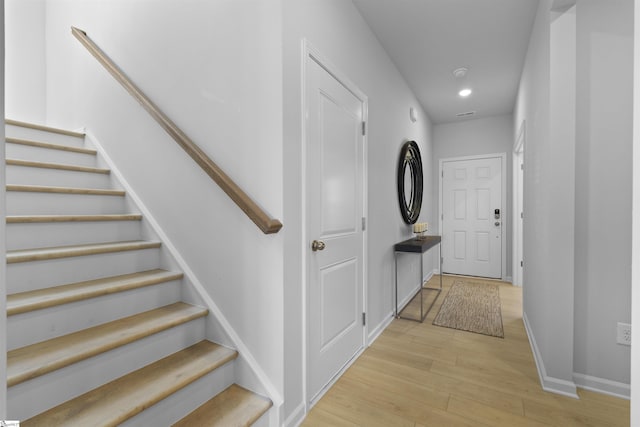 stairway with recessed lighting, wood finished floors, and baseboards