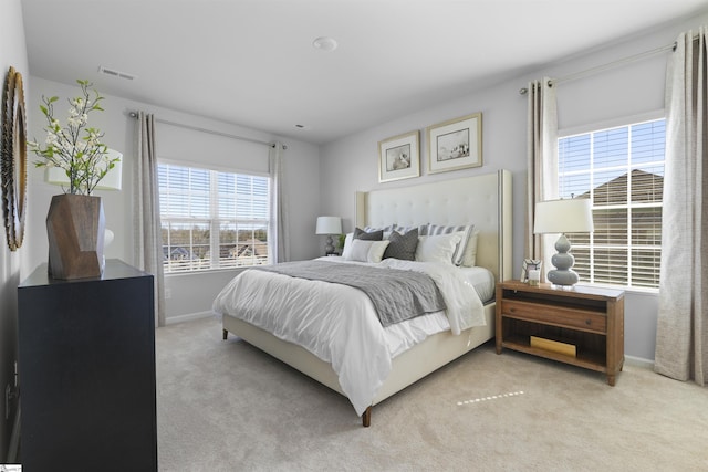 bedroom featuring light colored carpet, visible vents, and baseboards