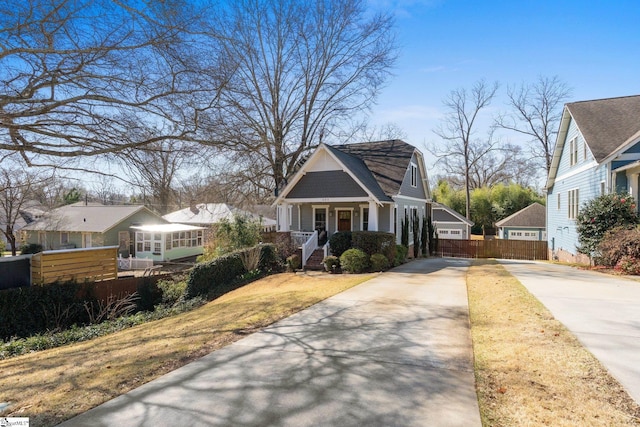 view of front of property with fence, covered porch, and driveway