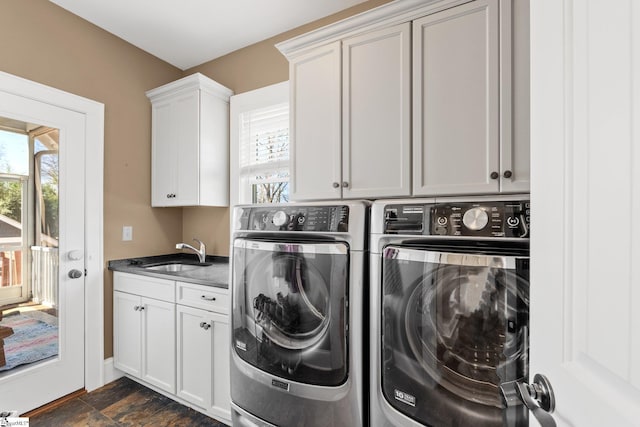 clothes washing area with cabinet space, independent washer and dryer, stone finish flooring, and a sink