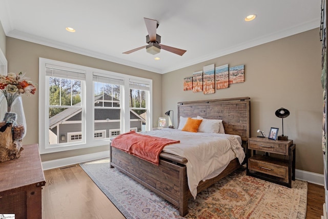 bedroom with crown molding, recessed lighting, wood finished floors, and baseboards