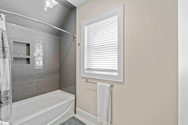 full bath featuring shower / bath combination with curtain and baseboards