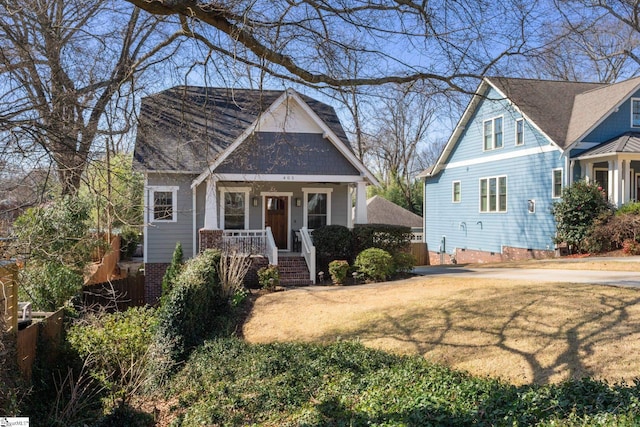 view of front facade featuring a porch, a front lawn, and crawl space