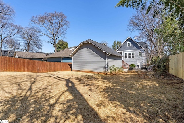 back of property featuring a yard and a fenced backyard