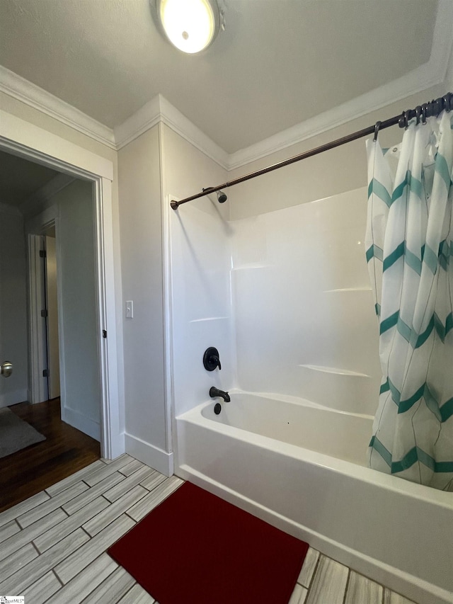 bathroom featuring shower / tub combo, ornamental molding, baseboards, and wood finish floors