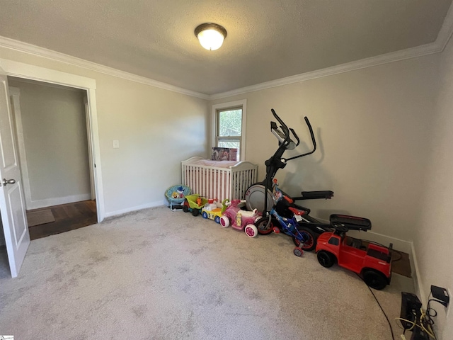 workout area with baseboards, a textured ceiling, ornamental molding, and carpet flooring