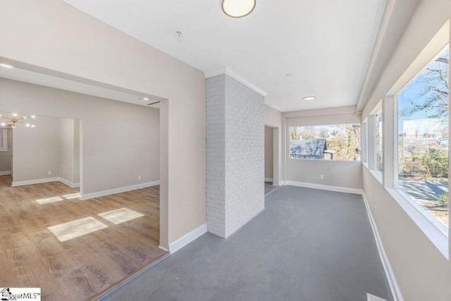 interior space with baseboards, concrete flooring, and ornate columns