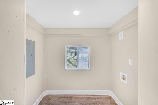 laundry room featuring baseboards, electric panel, laundry area, hookup for a washing machine, and wood finished floors