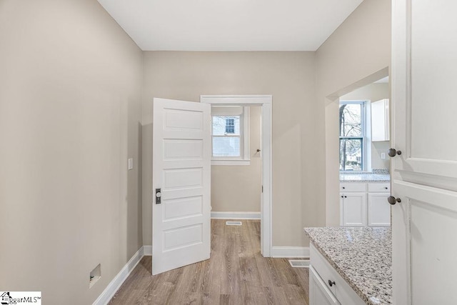 interior space featuring light wood-style flooring, visible vents, and baseboards