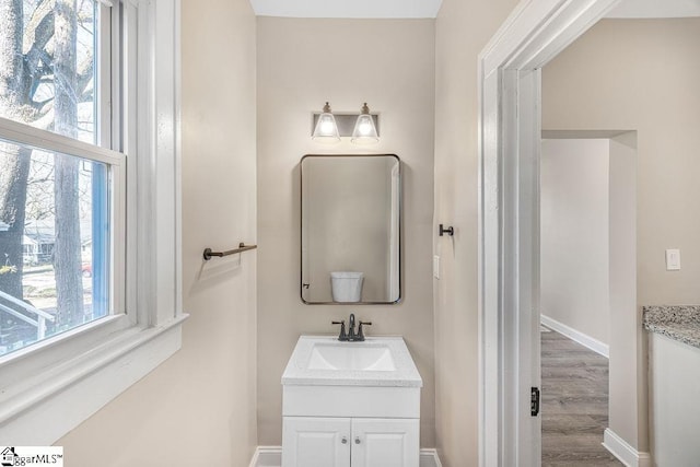 bathroom featuring vanity, wood finished floors, and baseboards