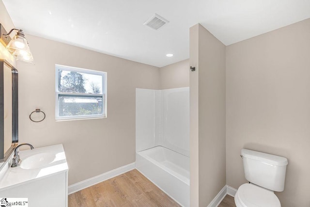 full bathroom with visible vents, toilet, wood finished floors, baseboards, and vanity