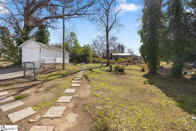 view of yard featuring an outbuilding, a storage shed, and fence