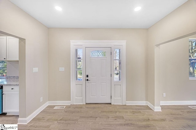 foyer entrance featuring recessed lighting, visible vents, light wood-type flooring, and baseboards