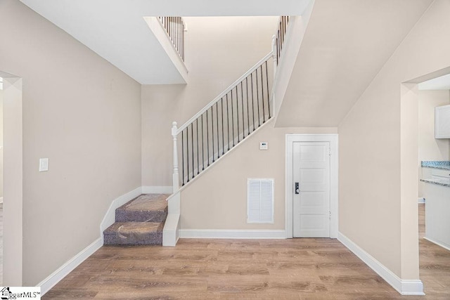 stairs with visible vents, baseboards, and wood finished floors