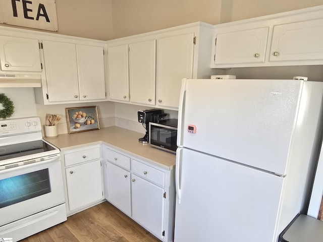 kitchen featuring under cabinet range hood, light wood-type flooring, light countertops, white cabinets, and white appliances