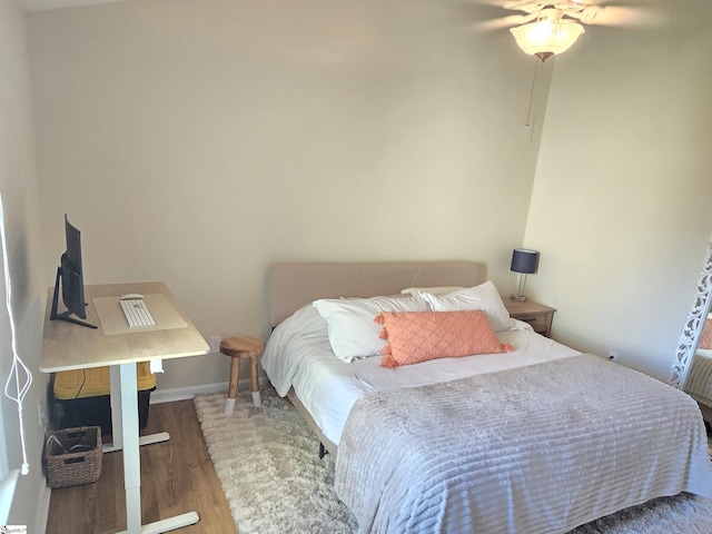 bedroom featuring baseboards and wood finished floors