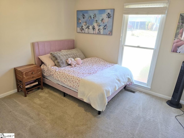 carpeted bedroom with multiple windows and baseboards