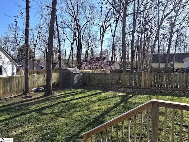 view of yard with an outbuilding, a shed, and a fenced backyard