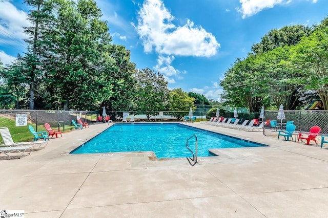 community pool featuring a patio area and fence