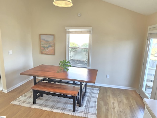 dining space featuring plenty of natural light, light wood-style flooring, and lofted ceiling