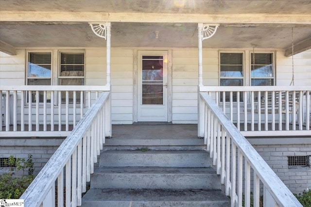 entrance to property with crawl space and a porch