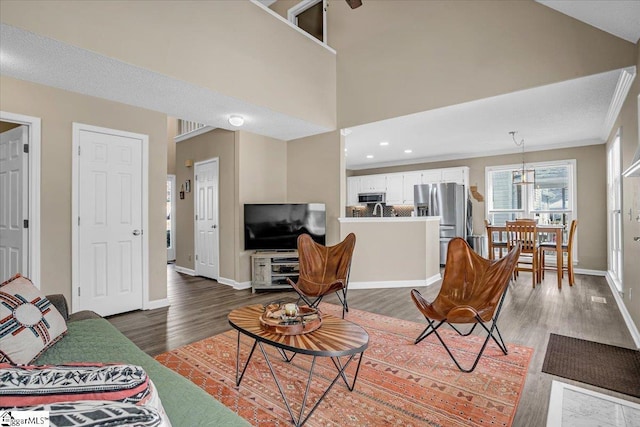 living room featuring dark wood-style floors, recessed lighting, baseboards, and a towering ceiling