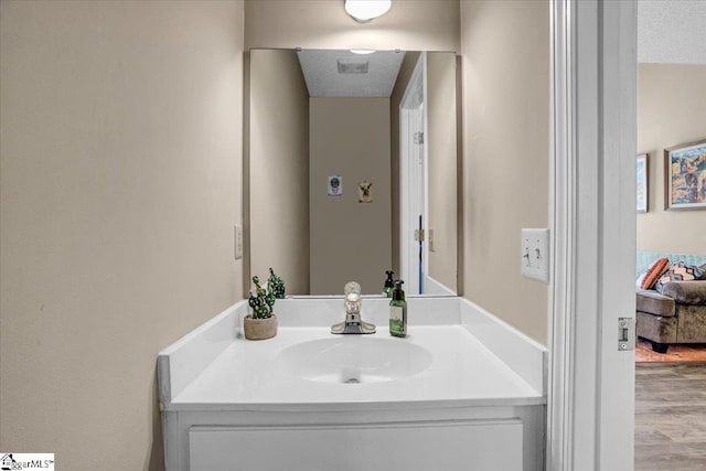 bathroom featuring a textured ceiling, wood finished floors, and vanity