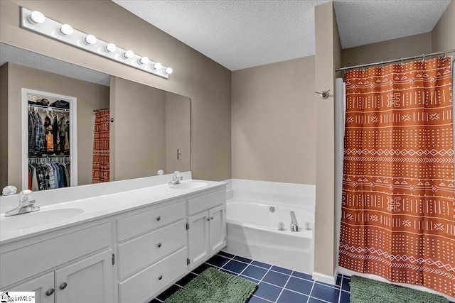 bathroom with tile patterned flooring, a textured ceiling, and a sink