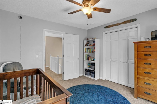 bedroom featuring a closet, carpet flooring, a textured ceiling, and ceiling fan