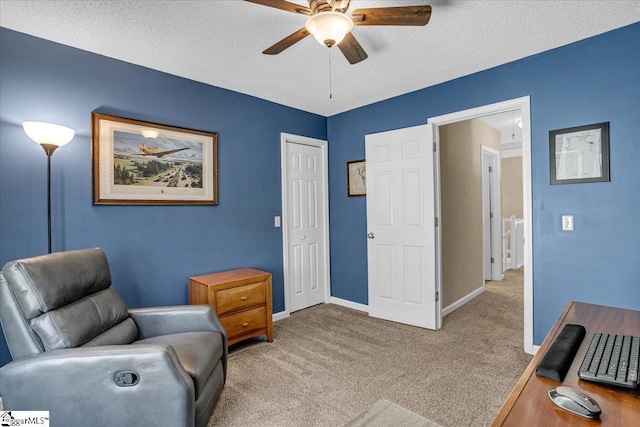 sitting room featuring a textured ceiling, baseboards, carpet, and a ceiling fan