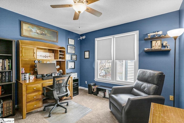 carpeted home office with ceiling fan, baseboards, and a textured ceiling