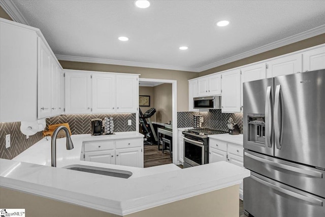 kitchen featuring a sink, stainless steel appliances, white cabinets, and light countertops