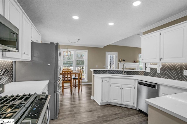 kitchen featuring appliances with stainless steel finishes, white cabinetry, and a sink