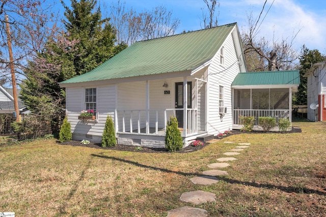 view of front of property featuring covered porch, a sunroom, a front lawn, crawl space, and metal roof