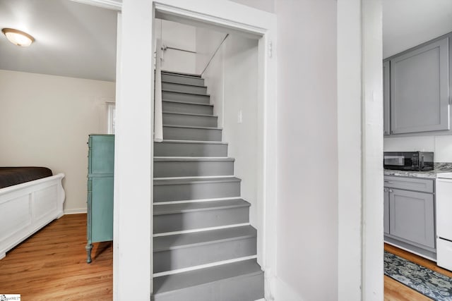 stairs featuring wood finished floors and baseboards