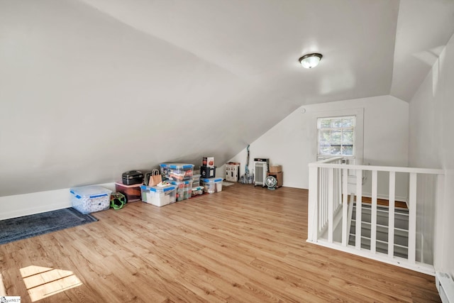 bonus room with lofted ceiling and wood finished floors