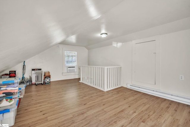 additional living space featuring a baseboard heating unit, vaulted ceiling, cooling unit, and wood finished floors