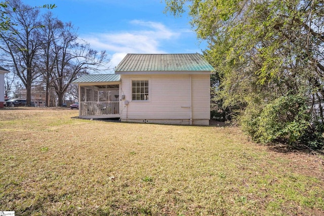 back of property with crawl space, a yard, metal roof, and a sunroom