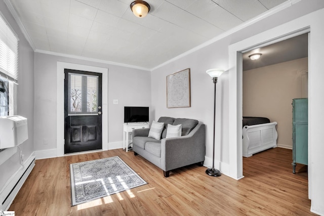 living room with light wood-style floors, baseboards, baseboard heating, and crown molding